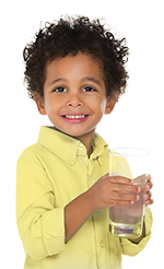 Boy with curly hair holding a glass of water
