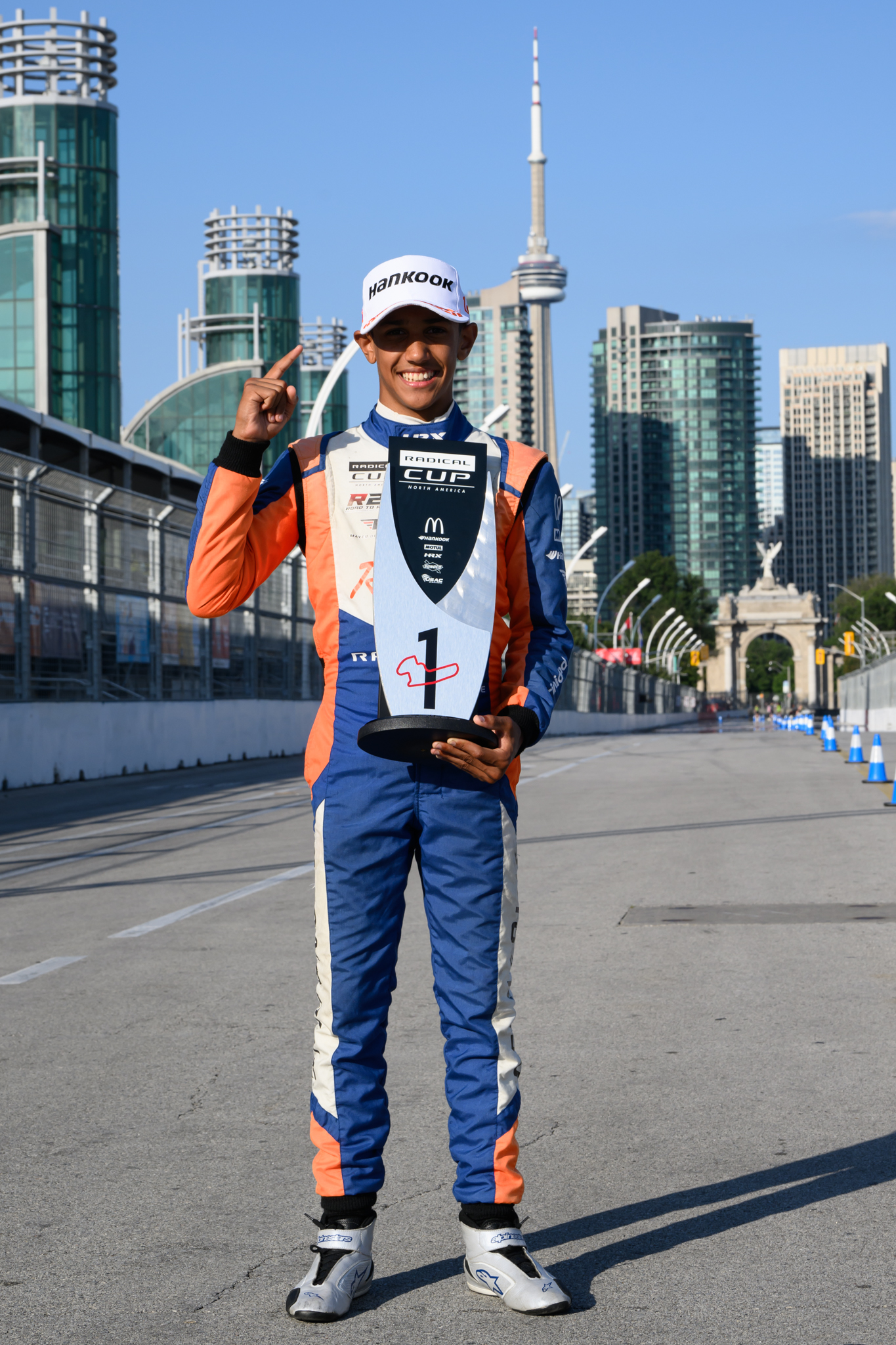 Mayer smiling with a trophy by the race track in downtown Toronto