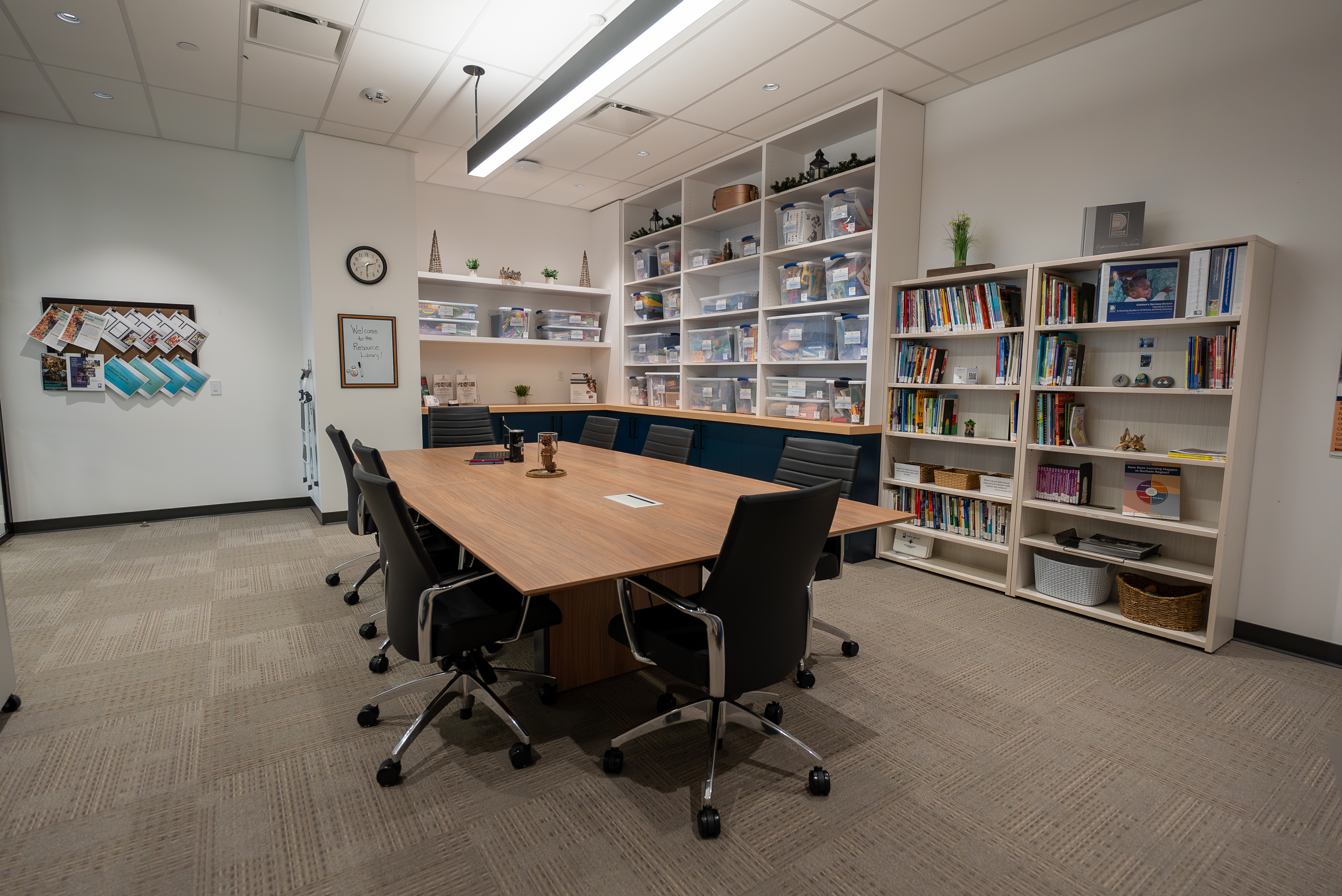 A room with table chairs and bookshelves