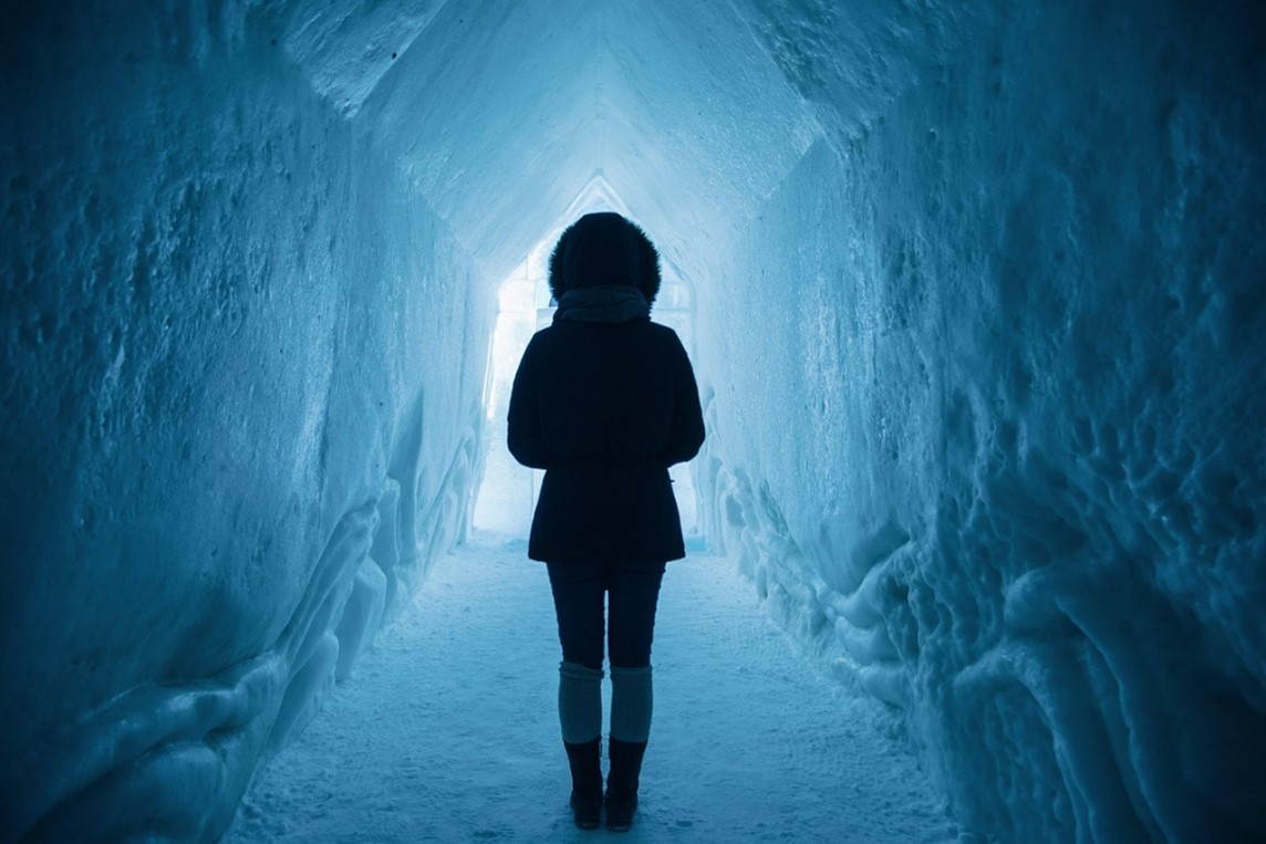 person standing in icy tunnel