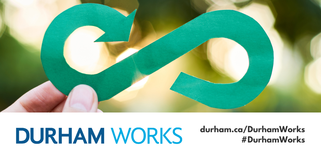 A picture of a person holding a green paper infinity symbol representing the circular economy with a banner underneath with the Durham Works logo and text reading durham.ca/DurhamWorks #DurhamWorks 