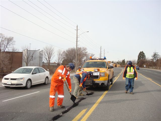 Works Department staff fixing pothole in road