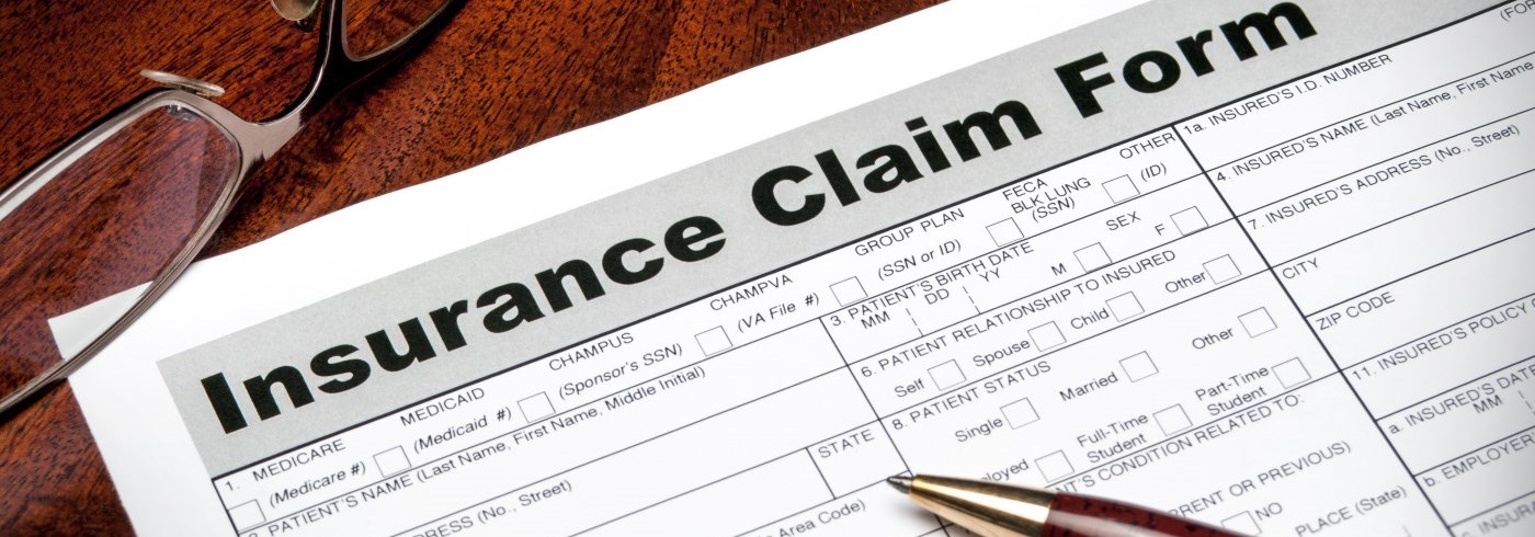 Insurance claim form with pen and eye glasses