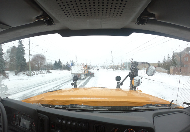 The view from inside of a snowplow during road clearing operations.
