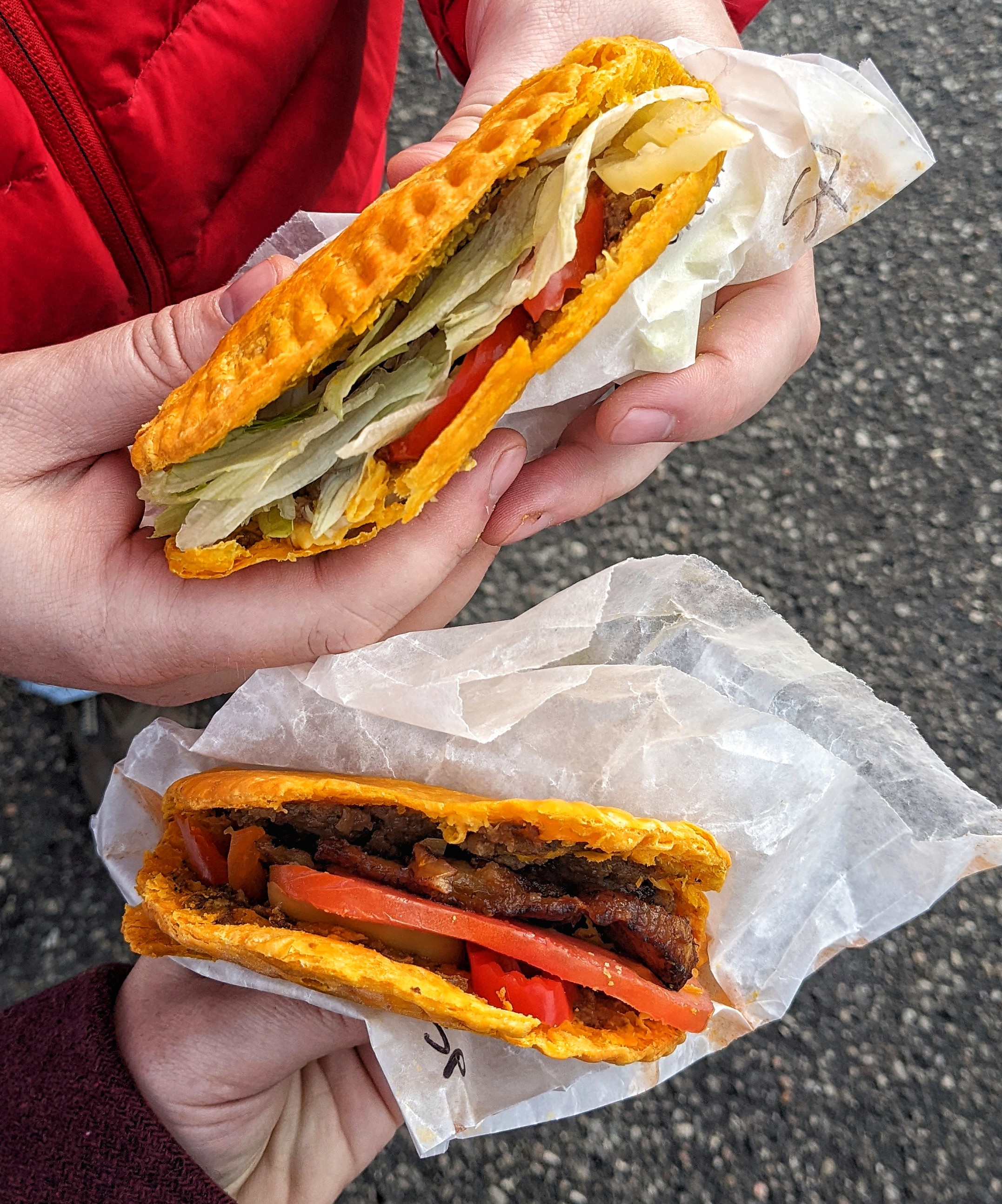 Aerial image of two people holding stuffed Jamaican patties