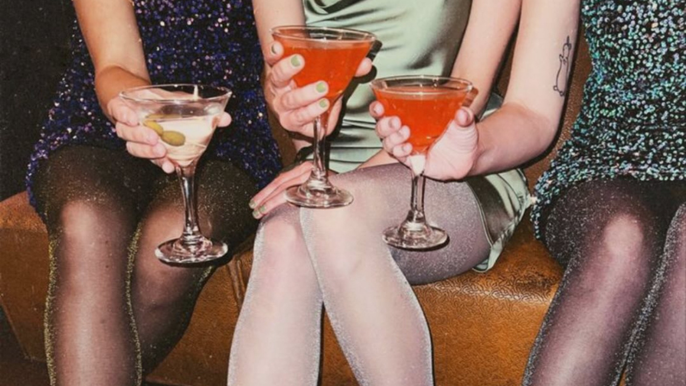 Image of three people dressed up for a night out holding cocktails in martini glasses