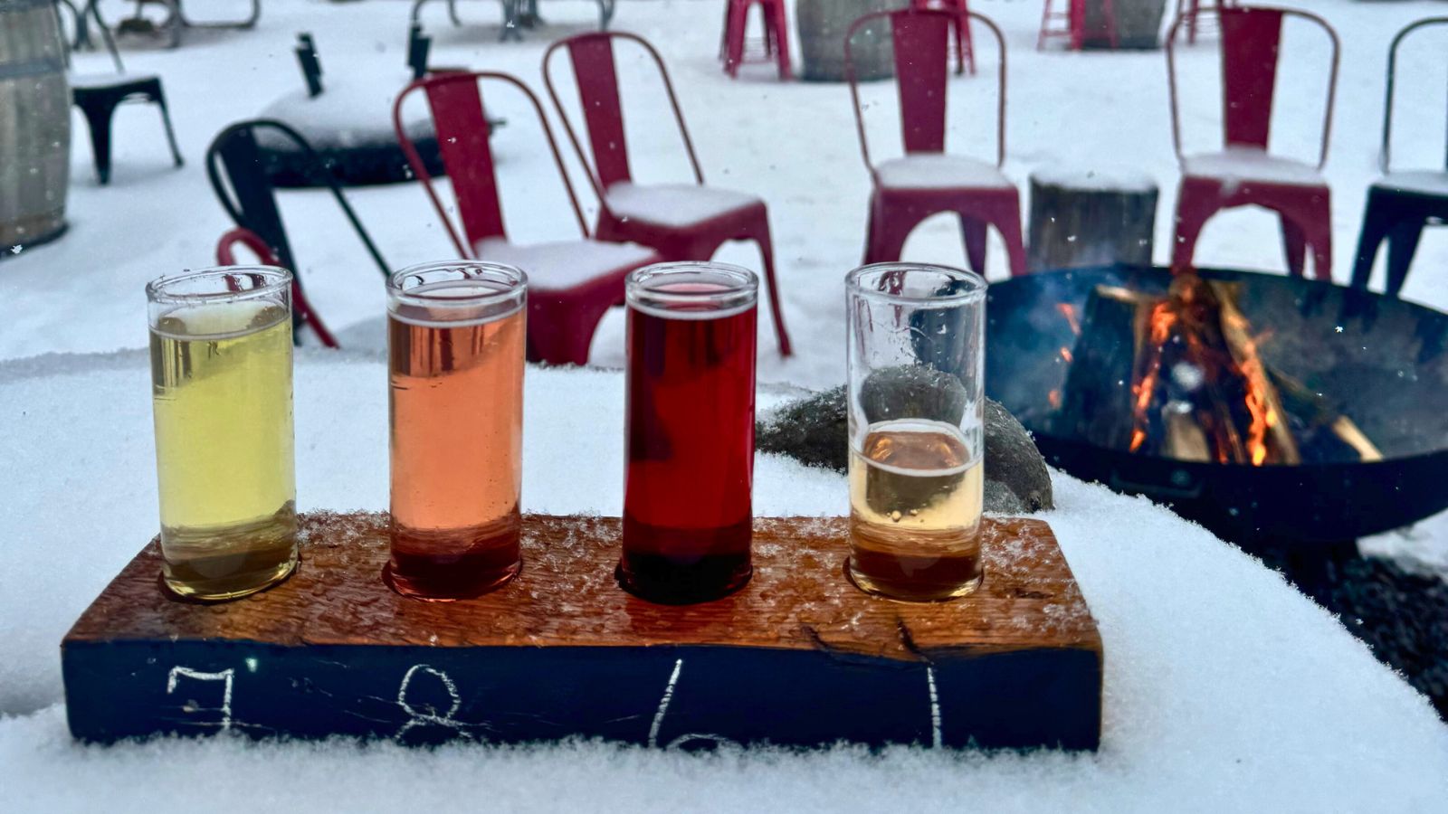 Image of a cider tasting flight sitting on a snowy table