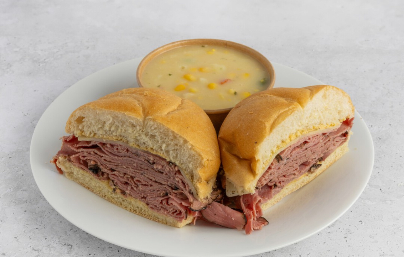 Image of a sandwich served on a plate with soup on the side