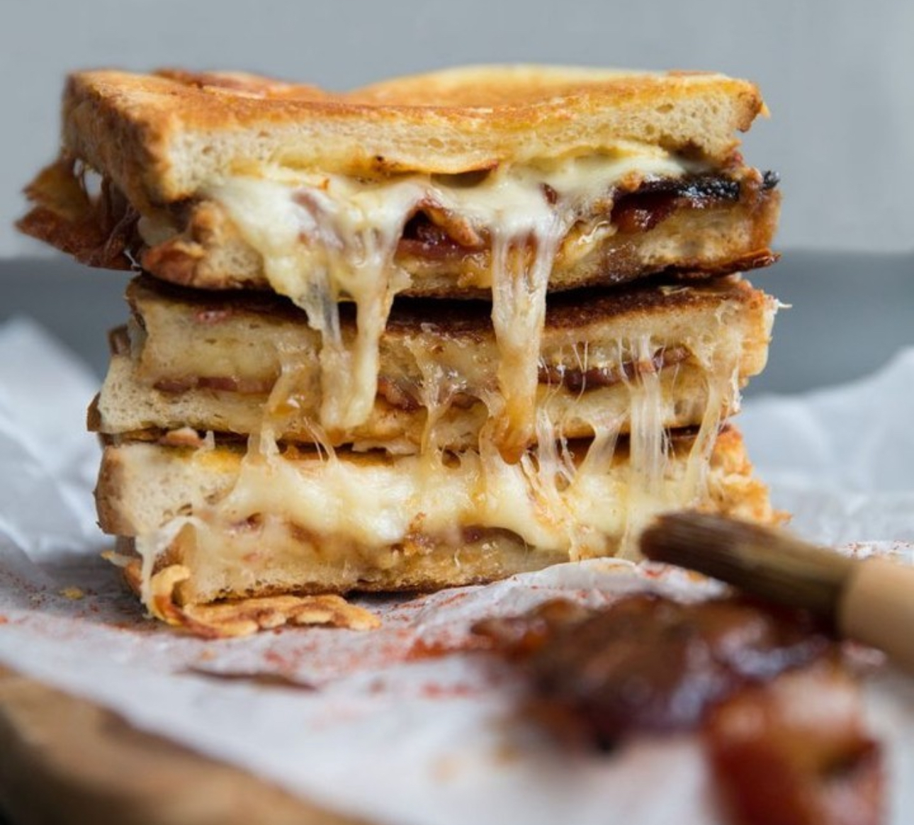 Image of a cross section of two halves of a sandwich with gooey cheese melting out