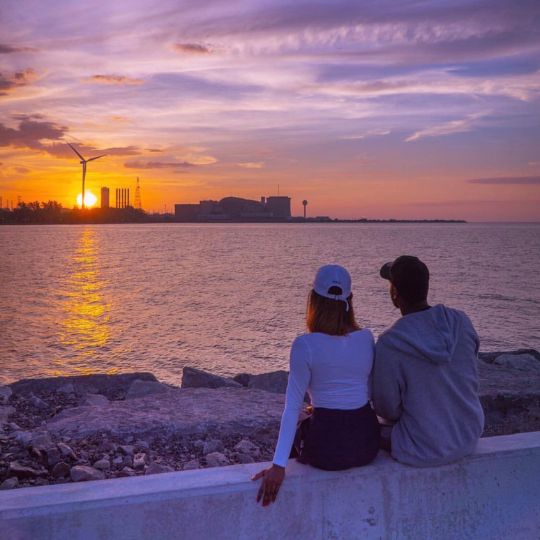 Two people watching the sunset over Lake Ontario in Pickering, Ontario