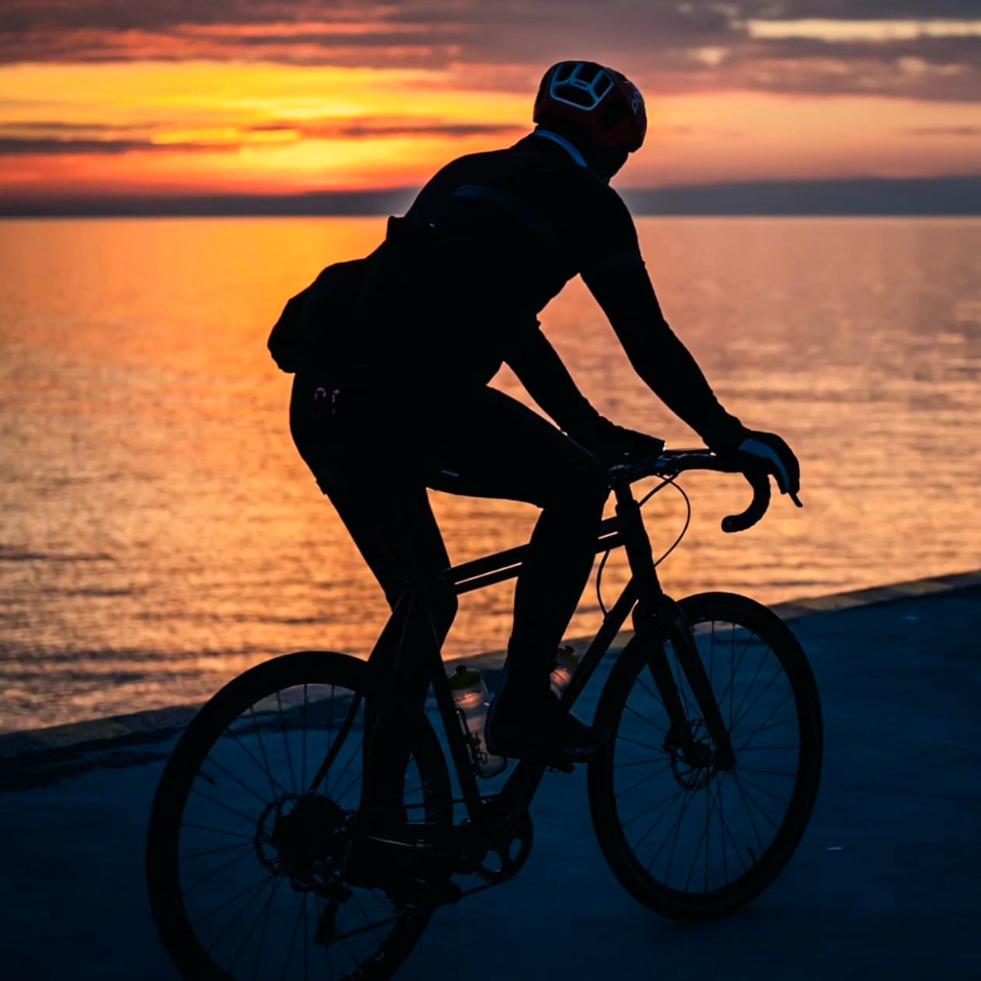 Person cycling along Lake Ontario waterfront at sunset in Durham Region, Ontario