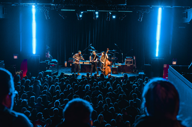 Band on stage with blue lighting at the Biltmore Theatre,