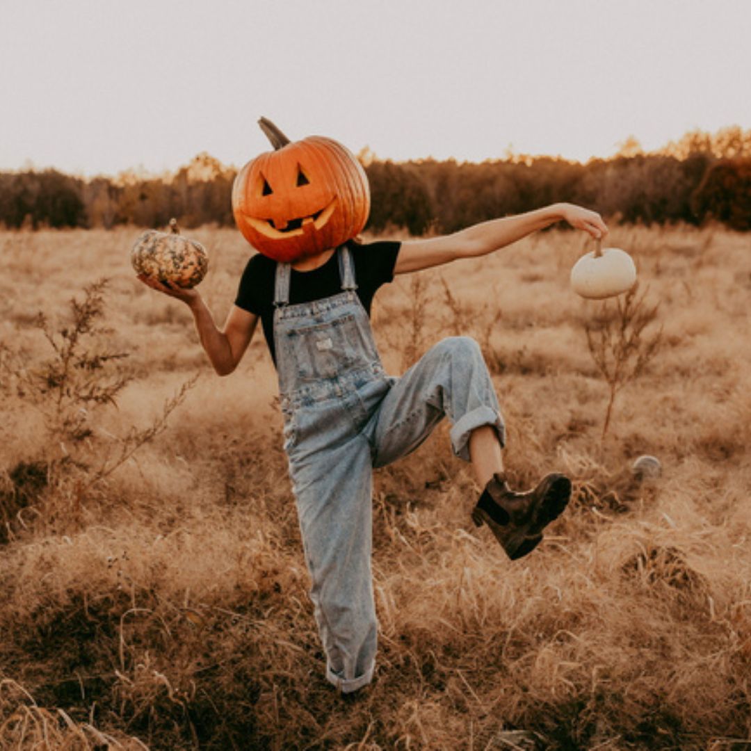 Person holding pumpkins at The Sunflower Farm in Beaverton, Ontario, Canada.