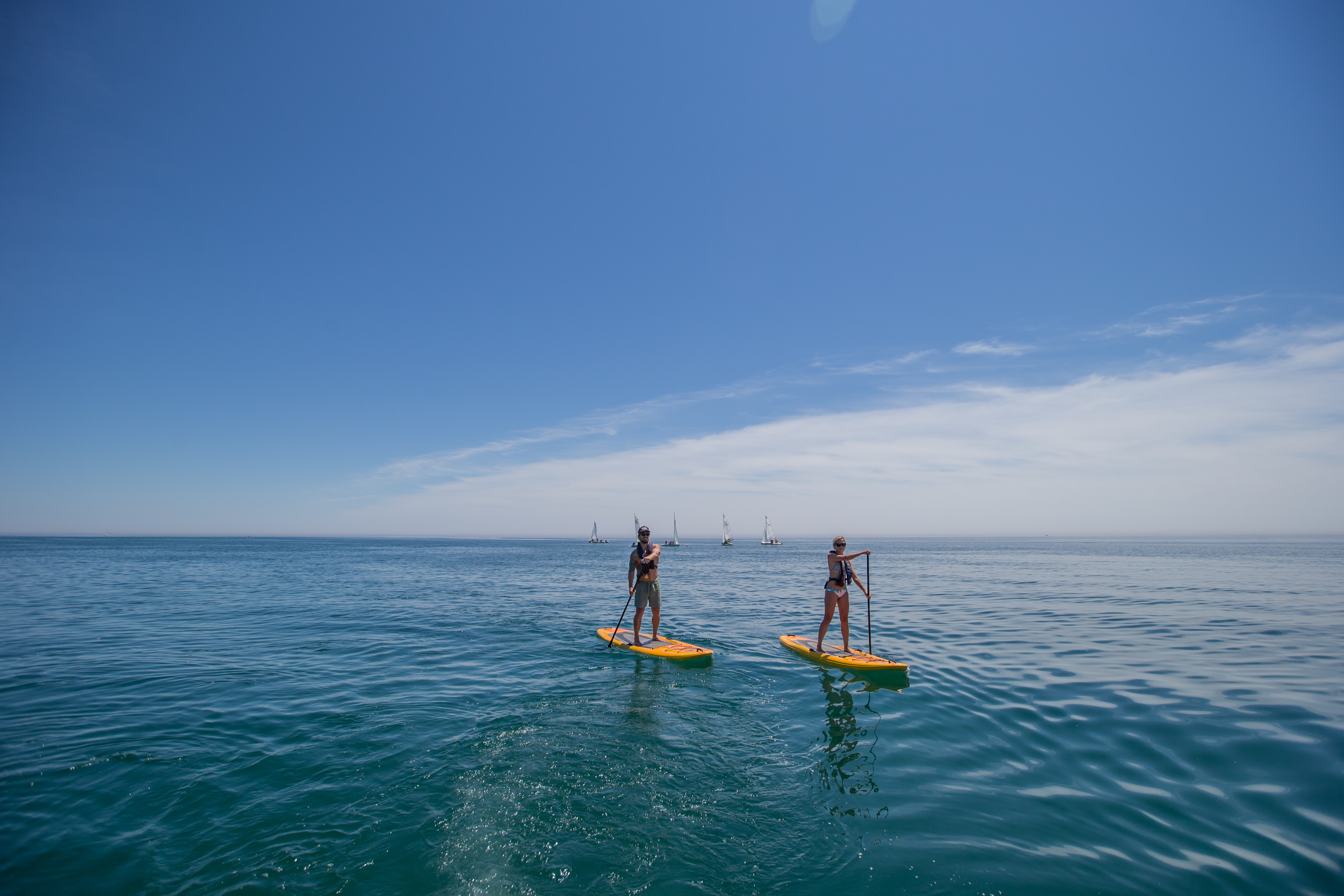 Image of two people on stand up paddle boards on a lake