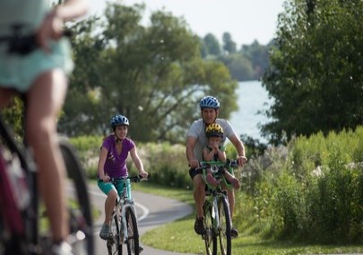 Image of a family riding bicycles on a waterfront trail