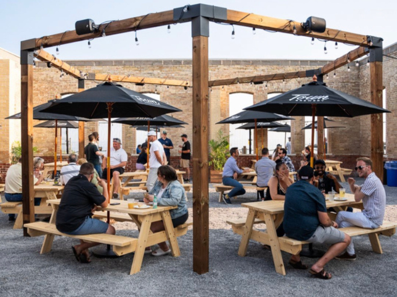 A lakeside beer garden full of people on a sunny, summer day