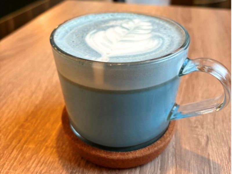 Image of a vanilla blue latte served in a mug with latte art on top