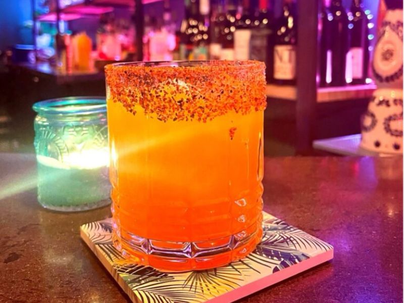 Image of a cocktail sitting on bar with a salt rim